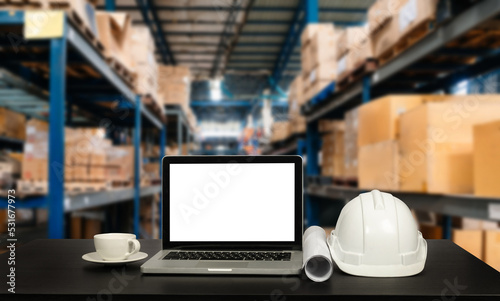 Front view of laptop computer and office construction on table in office blurred background.Architect concept..