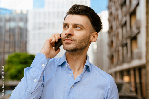 Bristle man wearing shirt talking on mobile phone at street