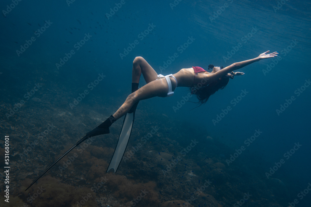 Female freediver fun diving in the ocean sea posing holding breath