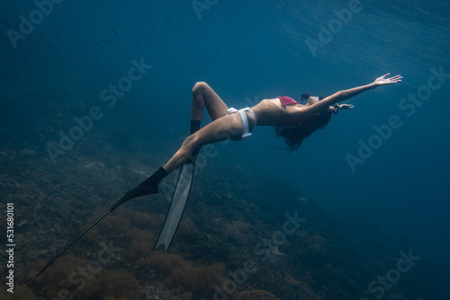 Female freediver fun diving in the ocean sea posing holding breath