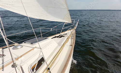 White sloop rigged yacht sailing in the Baltic sea after the storm. Waves, splashes, water surface. Cruise, summer vacations, regatta, sport, leisure activity, tourism, wanderlust concepts