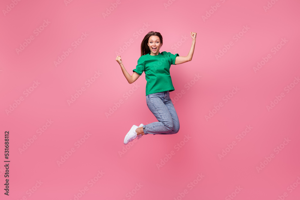 Full length photo of overjoyed energetic person jumping raise fists shout yes isolated on pink color background Full length photo of overjoyed energetic person jumping raise fists shout yes isolated on pink color background