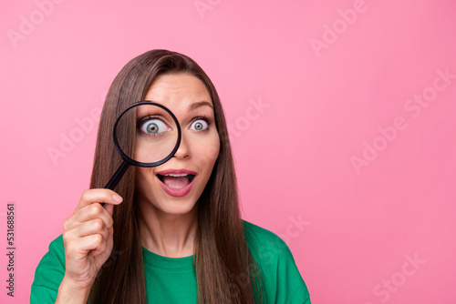 Portrait of sweet lovely pretty girl dressed green t-shirt hold magnifying glass on eye open mouth isolated on pink color background