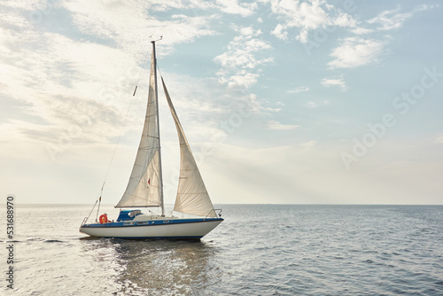 White sloop rigged yacht sailing in the Baltic sea on a clear day. Transportation, cruise, yachting, regatta, sport, recreation themes. Travel, exploring, wanderlust concepts