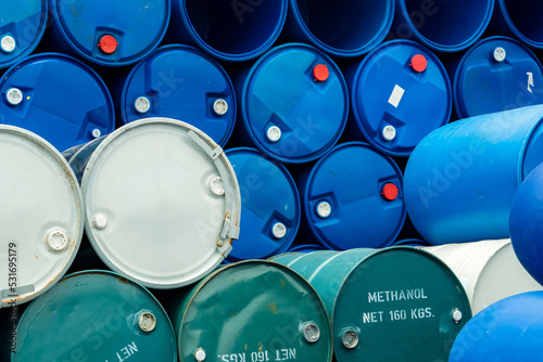 Old chemical barrels. Stack of blue methanol or methyl alcohol drum. Steel chemical tank. Toxic waste. Chemical barrel with toxic warning symbol. Industrial waste in drum. Hazard waste storage.