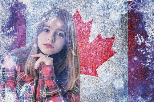 Teenage girl on frozen background with flag of Canada. Concept of crisis in America in winter. Energy crisis. photo