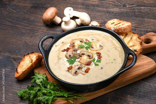 Mushroom champignon soup with bread and fresh mushrooms. top view