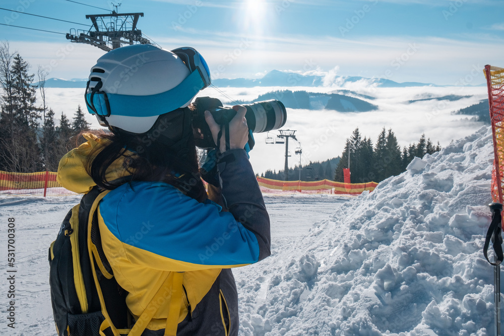 woman skier taking picture of mountains