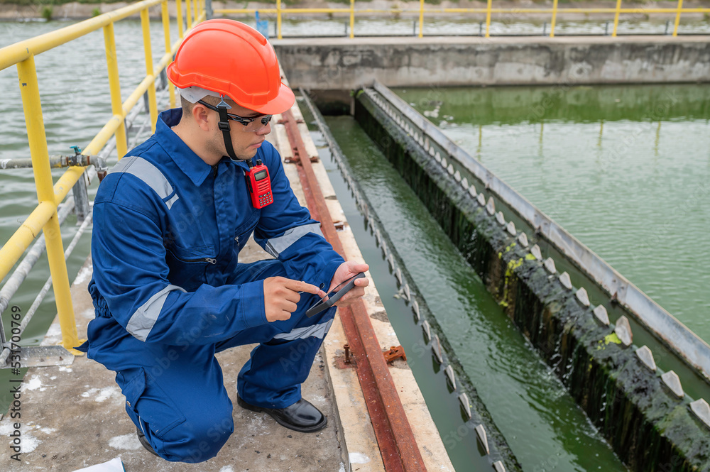 Water plant maintenance technicians, mechanical engineers check the control system at the water treatment plant. Water plant maintenance technicians, mechanical engineers check the control system at the water treatment plant.