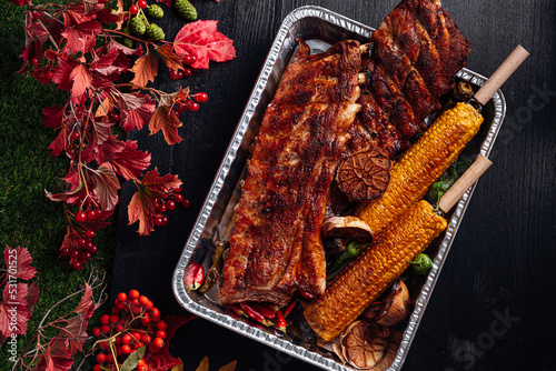 autumn bbq, grilled pork ribs, corn and grilled peppers. baked garlic. autumn grill party concept. Thanksgiving Day. autumn harvest.
