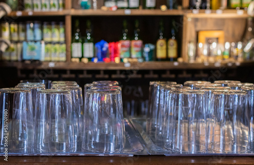 crystal glasses on the bar counter, out-of-focus bottle background concept