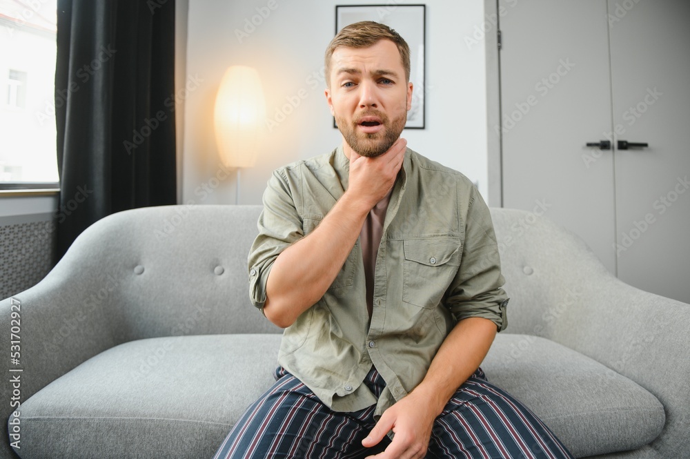 Sore throat. Dark-haired young man having a sore throat. Sore throat. Dark-haired young man having a sore throat.