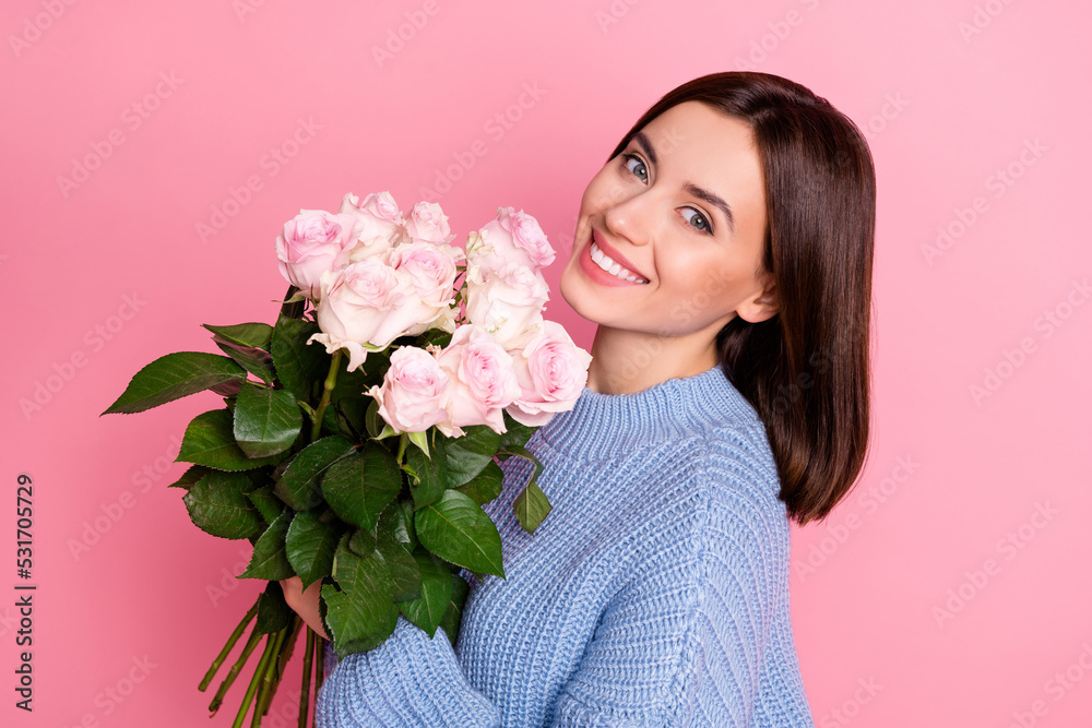Profile portrait of lovely cute person hold rose flowers beaming smile isolated on pink color background Profile portrait of lovely cute person hold rose flowers beaming smile isolated on pink color background