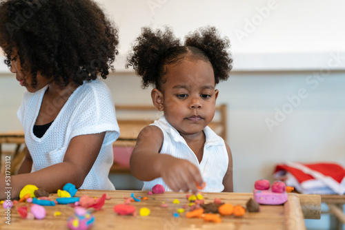 Two African American little child girl playing together at home. Happy children girl having fun together