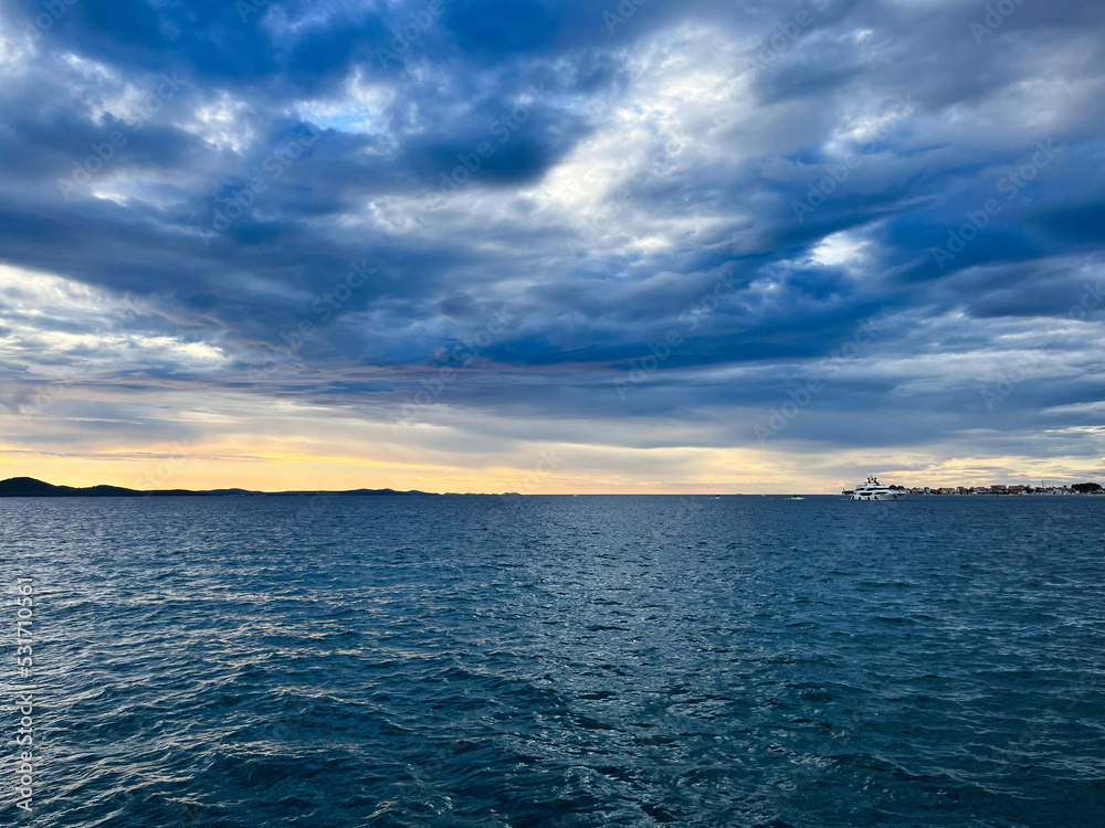 Evening sea view, cloudy sky and yellow sun light, sea horizon Evening sea view, cloudy sky and yellow sun light, sea horizon