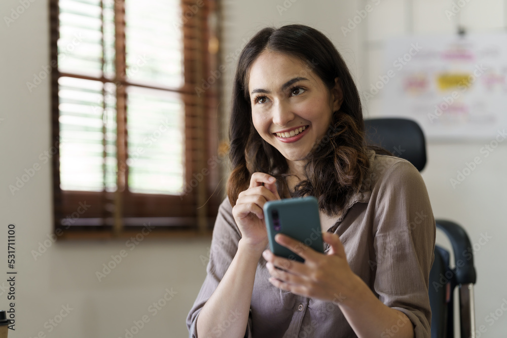 Attractive asian young woman using smartphone working office desk in office workplace.