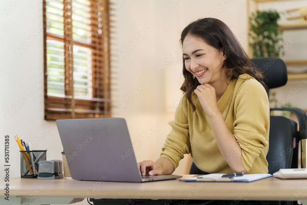 Asian thai businesswoman using laptop at working desk in modern office, busy job but feeling happy. Asian thai businesswoman using laptop at working desk in modern office, busy job but feeling happy.