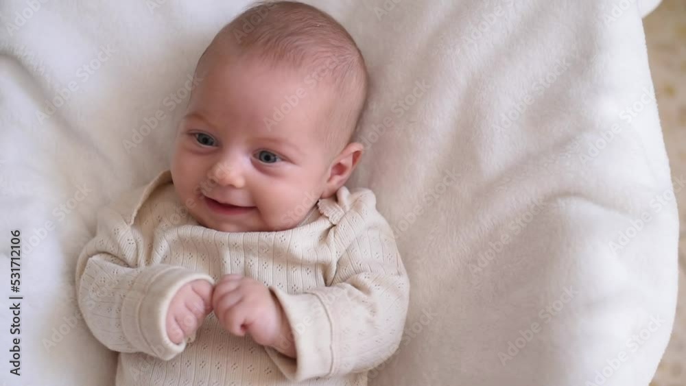 Newborn lies in child seat on white blanket. Kid in white t-shirt with cute smile. Childs - happiness for family. New worries and lifestyle. close up Newborn lies in child seat on white blanket. Kid in white t-shirt with cute smile. Childs - happiness for family. New worries and lifestyle. close up