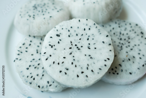 slice of white color dragon fruit on a chopping board.