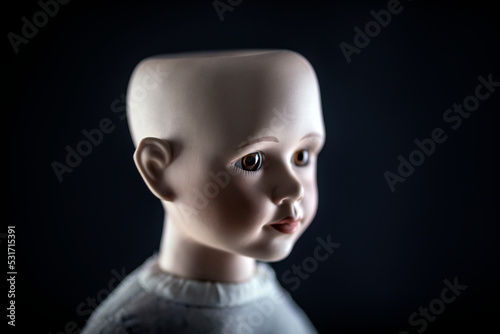 Creepy doll face on dark background