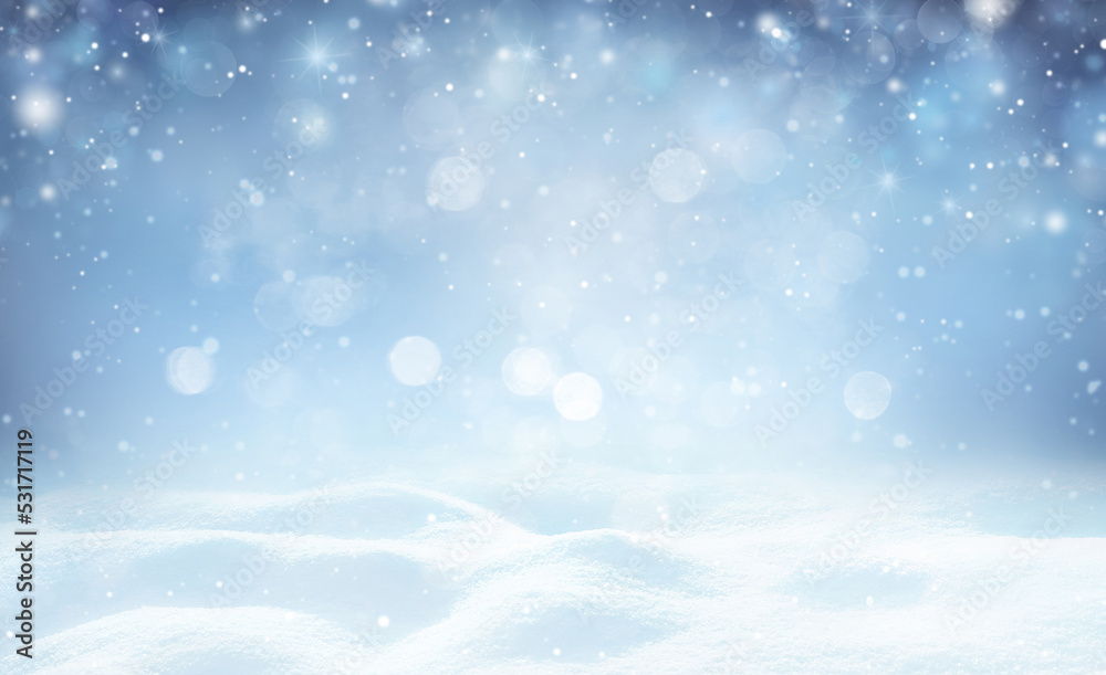 Winter background - sparkling falling snow against a dark blue sky and white snowdrifts.