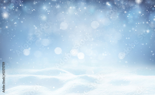 Winter background - sparkling falling snow against a dark blue sky and white snowdrifts. © Laura Pashkevich