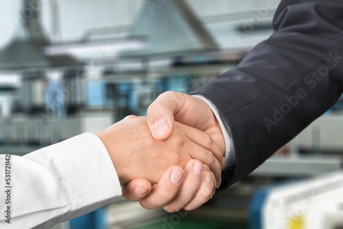 Business person handshake afterdeal, warehouse background