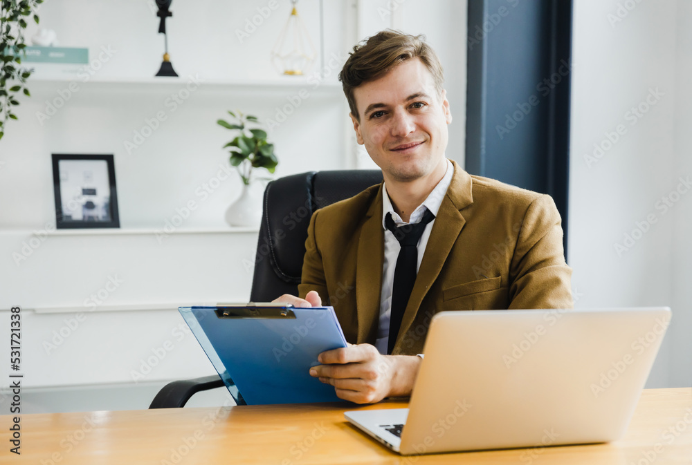 Smiling confident mature businessman leader looking at camera short note and sign on paper on table in office, happy and modern business man Smiling confident mature businessman leader looking at camera short note and sign on paper on table in office, happy and modern business man