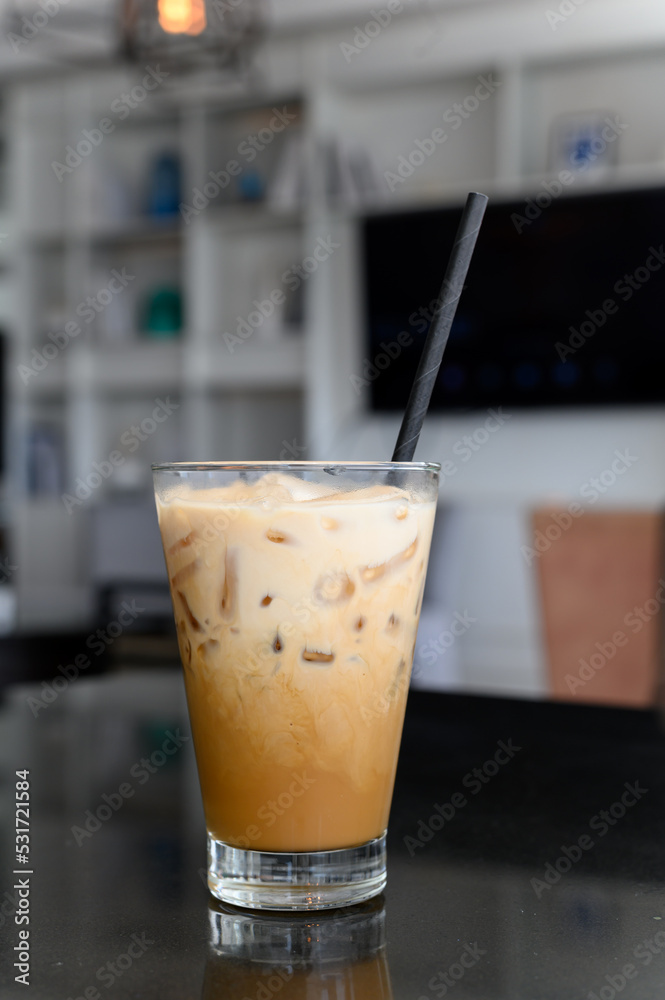 Ice cappuccino coffee with paper straw on black table in modern cafe coffee shop. Coffee Break. Ice cappuccino coffee with paper straw on black table in modern cafe coffee shop. Coffee Break.
