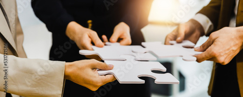 hand of successful business people connecting jigsaw puzzle. Business solutions, success and strategy concept, businesspeople hold jigsaw pieces connect puzzle seek for business solution  photo