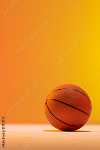 Image of orange basketball with copy space on orange to yellow background