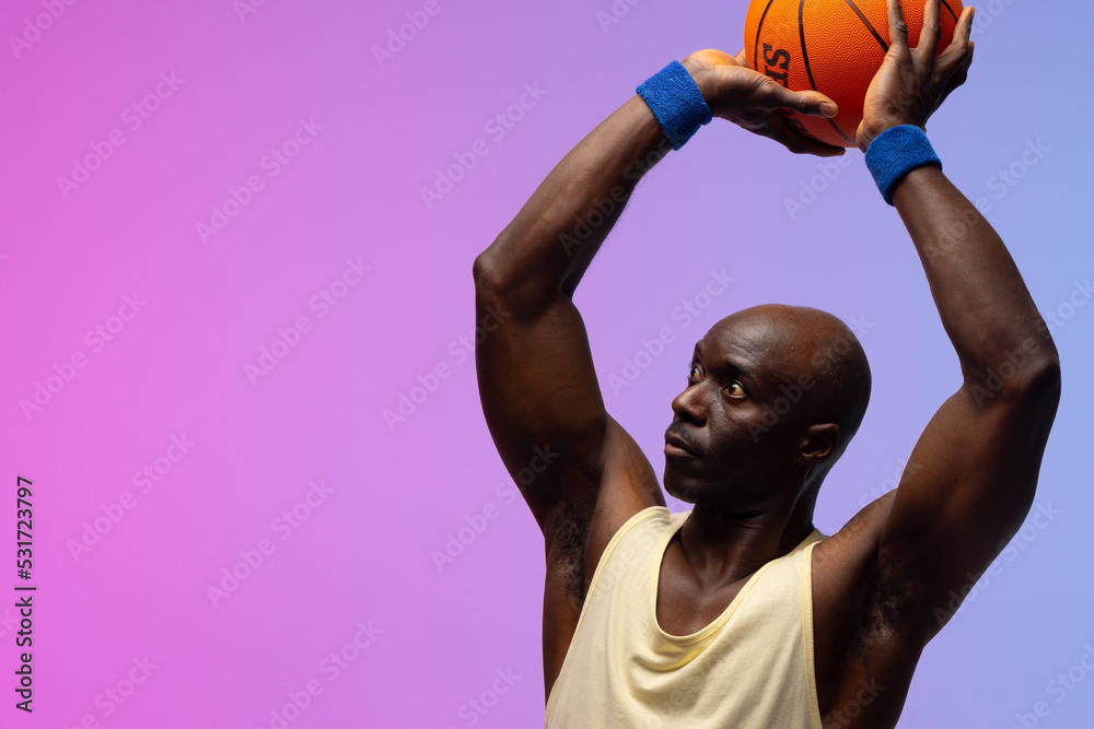 Image of african american basketball player with basketball on neon purple to pink background Image of african american basketball player with basketball on neon purple to pink background