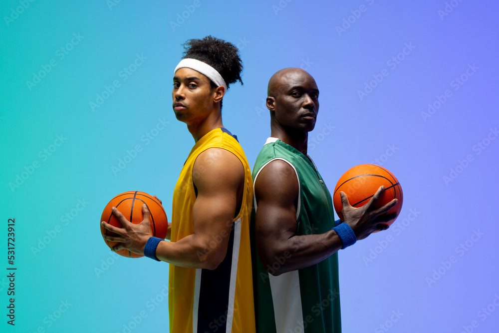 Image of portrait of two diverse basketball players with basketballs on purple to green background