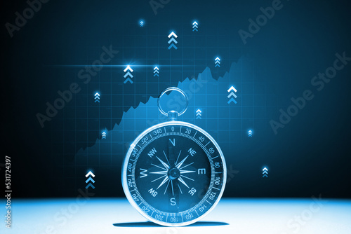 The concept of a successful way to invest and promote a business Compass with a hologram up arrows.