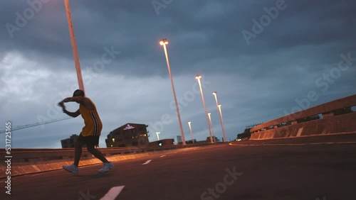 Hip hop street dancer, urban man and night performance with excited talent, energy and freedom outdoor. Silhouette, dark and creative city guy dancing with road movement, action and techno rave music photo