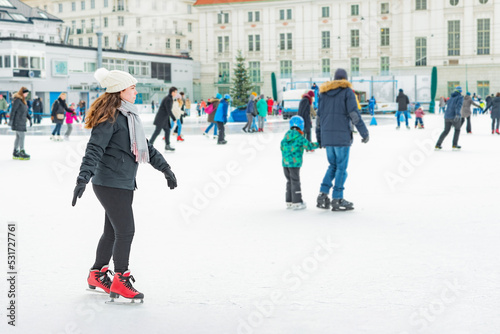 Young adult alone woman skating on ice. Enjoying sport in cold weather. Outdoor activities.