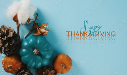 Cheerful Happy Thanksgiving flat lay background with blue and orange pumpkins for greeting of holiday. photo