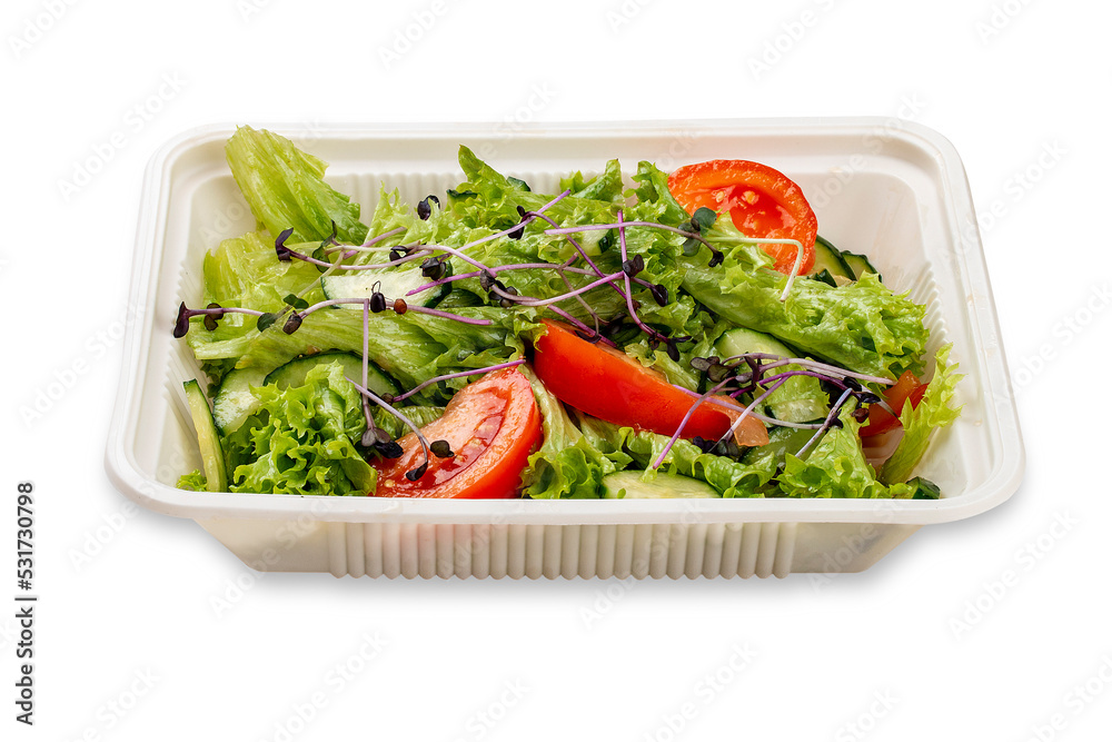 Salad with fresh vegetables and microgreens. In a plastic container. Food to go. On a light background. Salad with fresh vegetables and microgreens. In a plastic container. Food to go. On a light background.