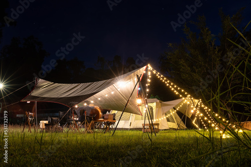 Night camping atmosphere. It is a low-light night shot with noise and grain. Long exposure photography causes moving parts to blur. There will be sharpness only at the selected focus point. © VR Studio