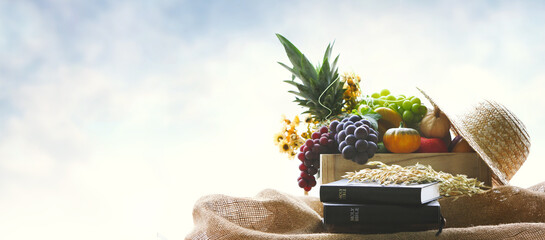 Church Thanksgiving Day fruit decoration with bible and harvested grain and crops background

