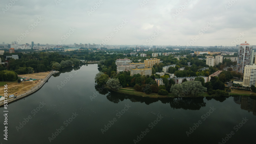 Lake in the city park. Urban landscape. Dormitory area of a big city. Aerial photography.