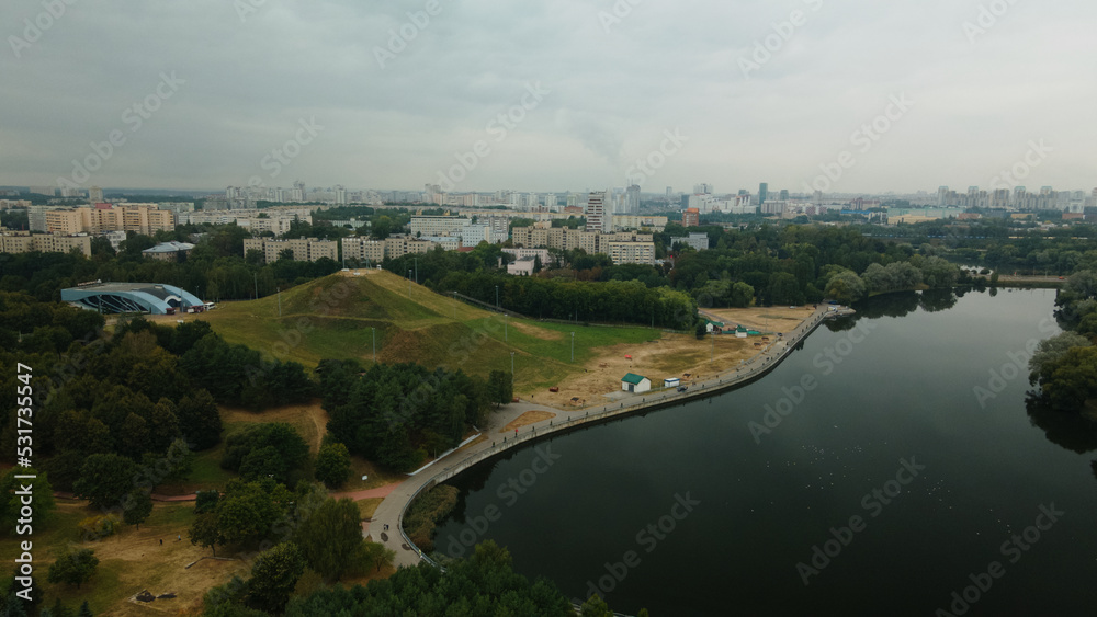 Lake in the city park. Ski center hill. Urban landscape. Sleeping area of a big city. Aerial photography.