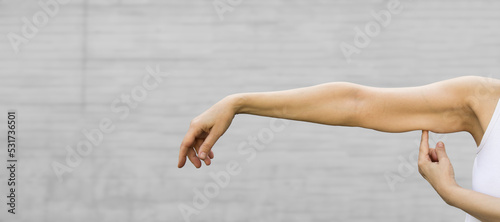 A woman shows the flabby muscles of the arm . Flabby Arm Syndrome (FAS). Effect of aging caused by loss of elasticity and muscle.Banner, copyspace.