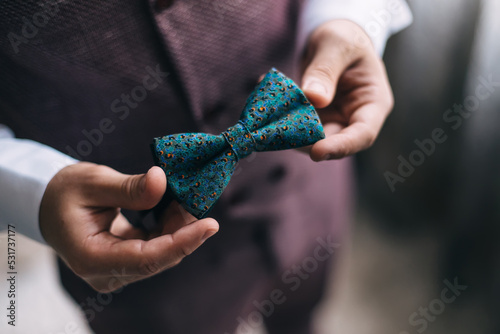 Obraz na płótnie close-up of a man's hand holding a green bow tie