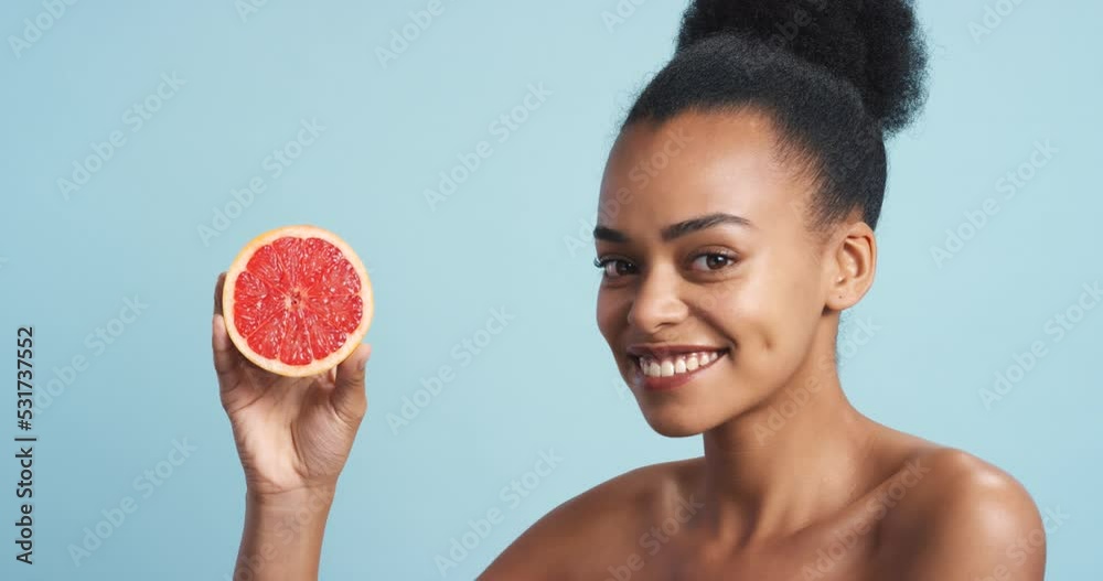 Health, wellness and black woman with a fruit with a healthy, nutrition and happy mindset. Organic food, vitamin c and organic skincare ingredient of a beauty model with good skin and blue background