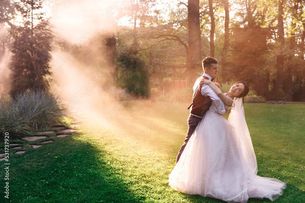 Amazing smiling wedding couple. A beautiful bride and a stylish groom. Romantic wedding moment, dancing in nature Amazing smiling wedding couple. A beautiful bride and a stylish groom. Romantic wedding moment, dancing in nature
