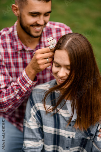 close-up of woman whose man decorates her hair with flowers
