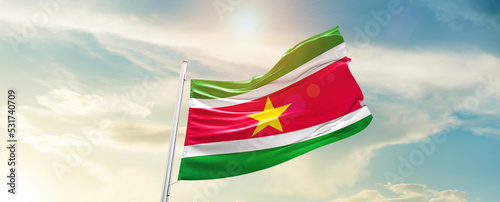 Suriname national flag cloth fabric waving on the sky - Image photo