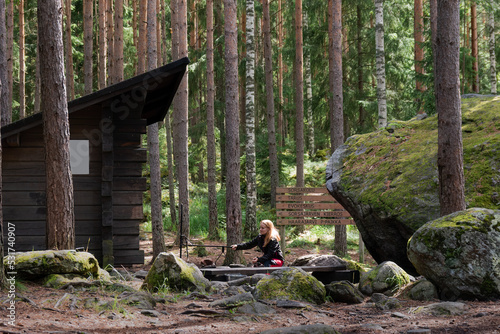Woman sitting on the Sorsakolu campfire site in the Evo hiking area, Hameenlinna, Finland photo
