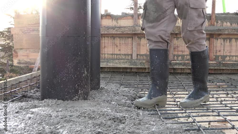 Concreting of reinforced concrete slab. Worker concretes foundation